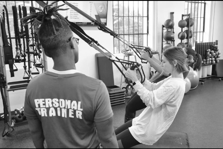 The owner of BAM doing a personal training session with a client doing lay pull downs