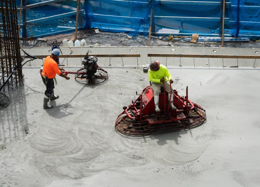A website development overhead shot capturing 2 workers lay and smooth out cement in a construction zone
